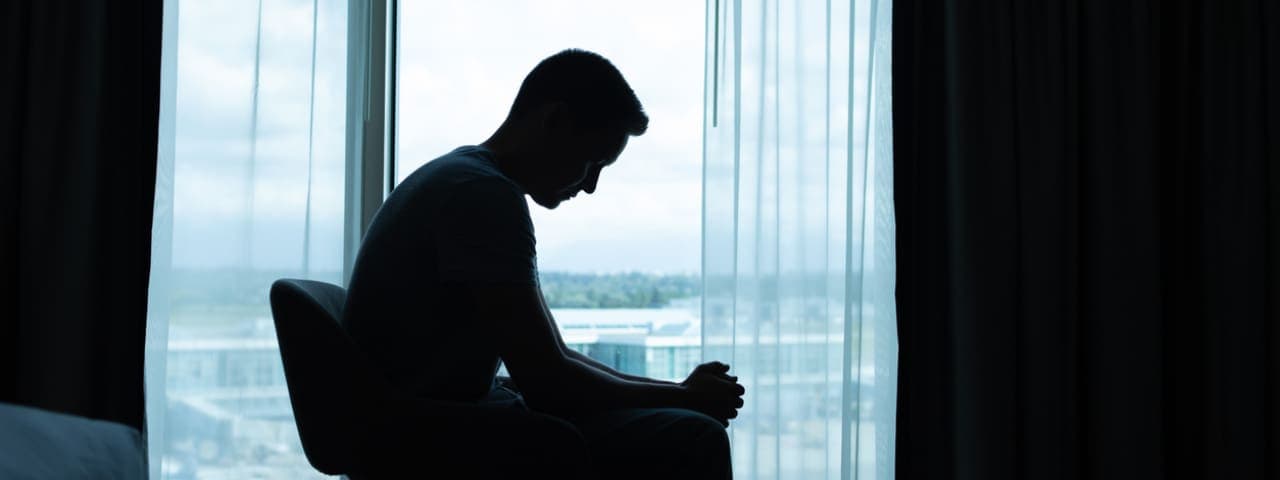 A man sitting alone in a dark room