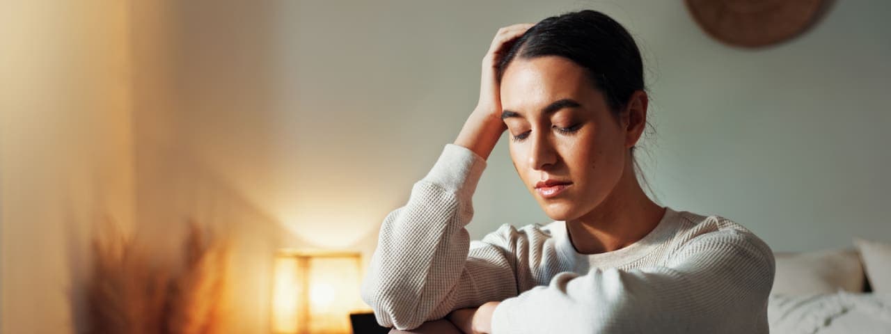 A woman holding her head and looking worried